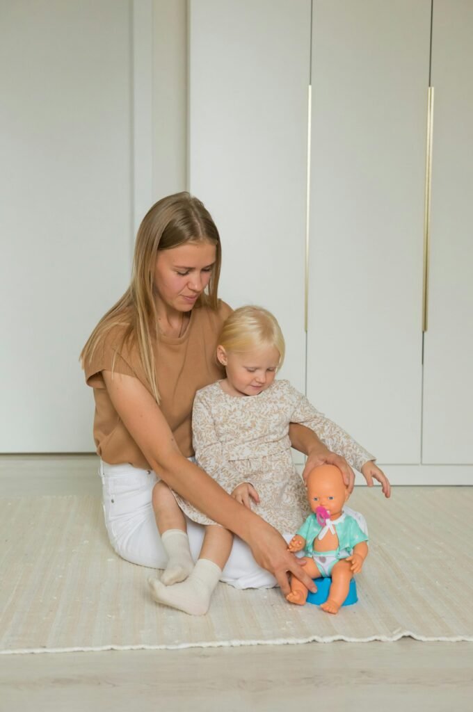 image of child learning potty training with a doll