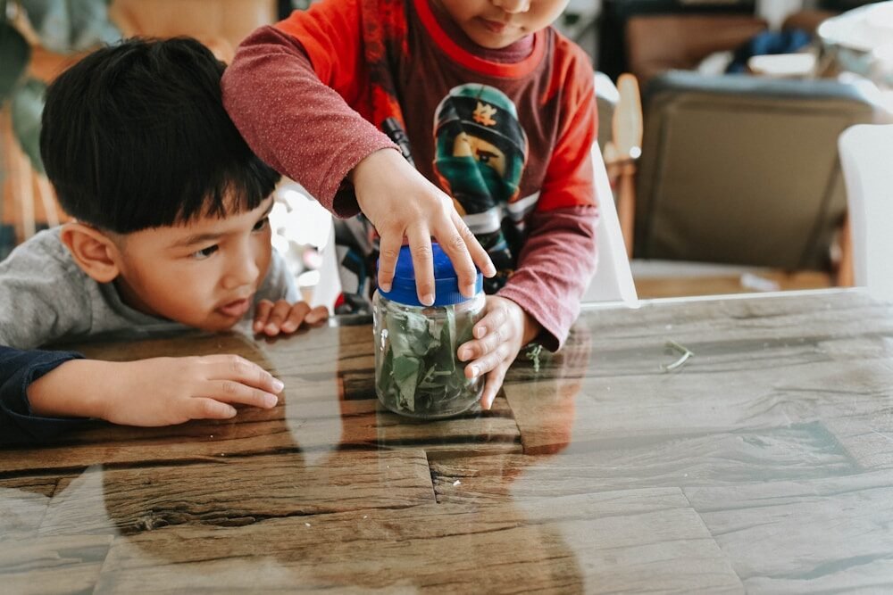 two children are playing with a jar of money