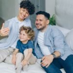 a man and two children sitting on a bed