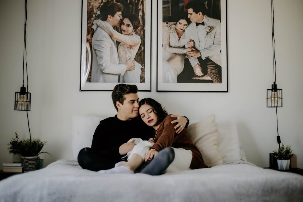 man and woman lying on bed with baby