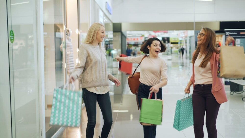 Three women with shopping bags in a mall