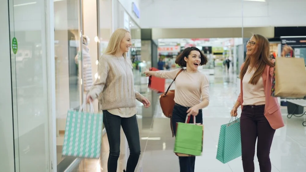 Three women with shopping bags in a mall