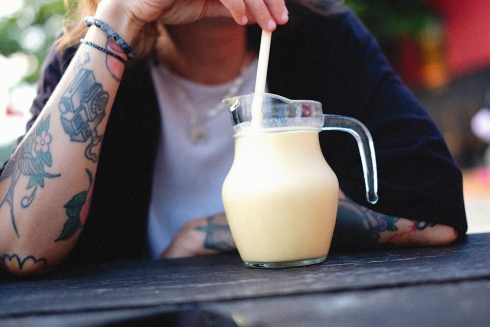a person holding a glass with a drink in it