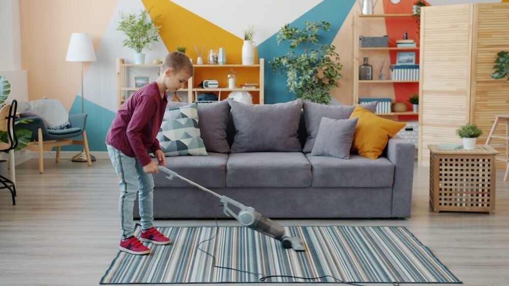 Young girl vacuuming a striped rug in a living room