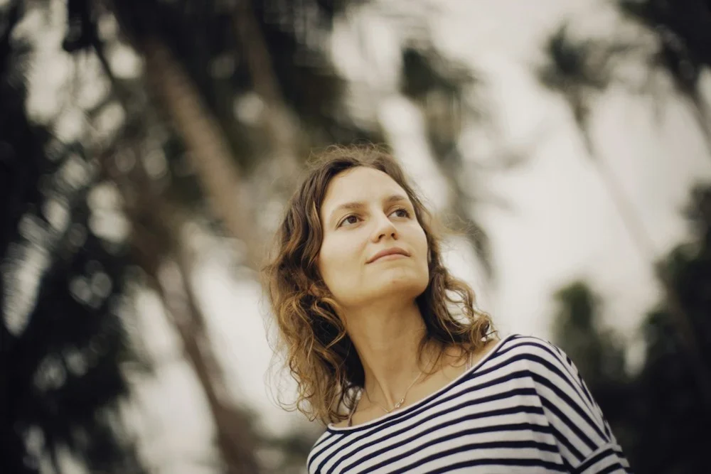 a woman standing in front of palm trees