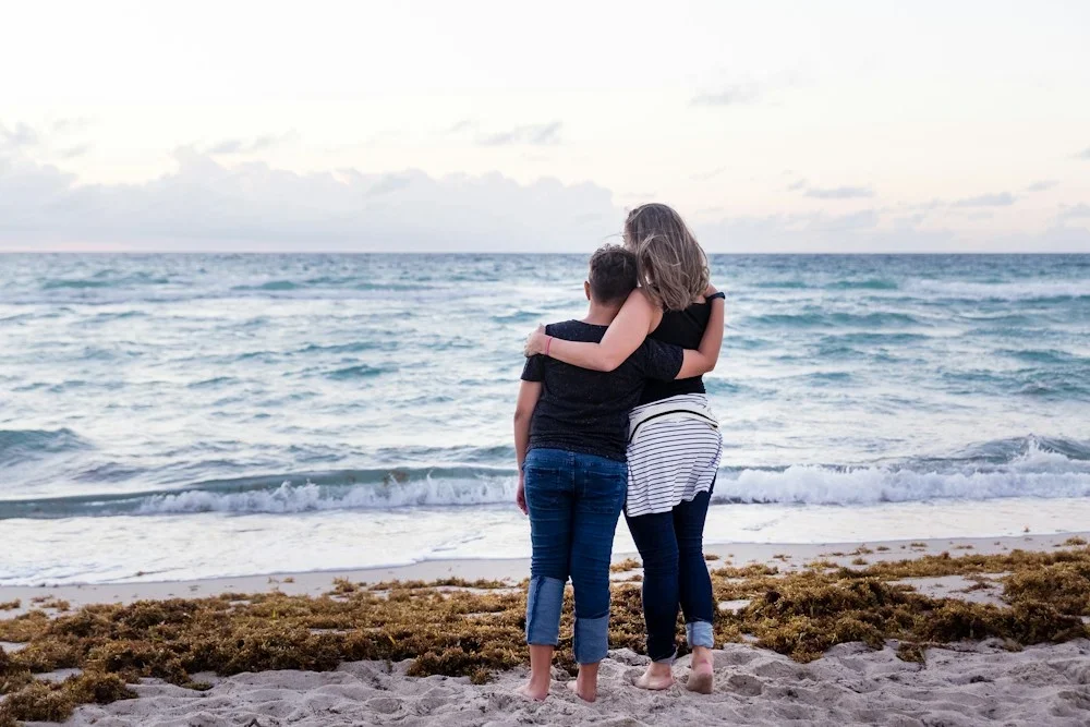 two woman standing on seashore near sea