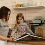girl in gray crew neck t-shirt holding white tablet computer